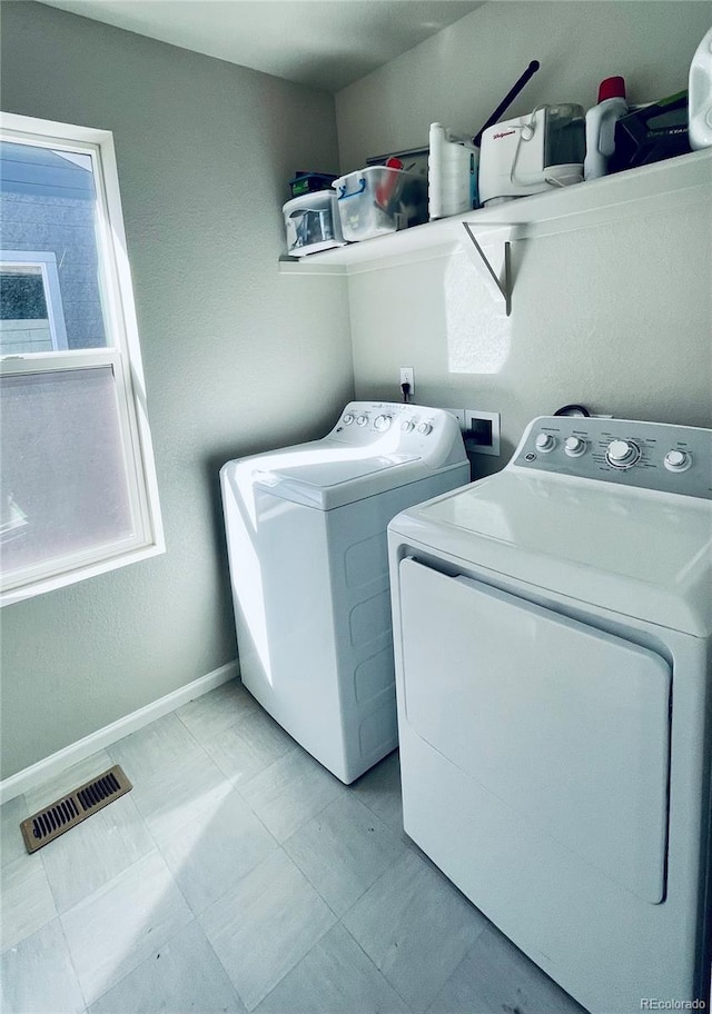 clothes washing area with a wealth of natural light and separate washer and dryer