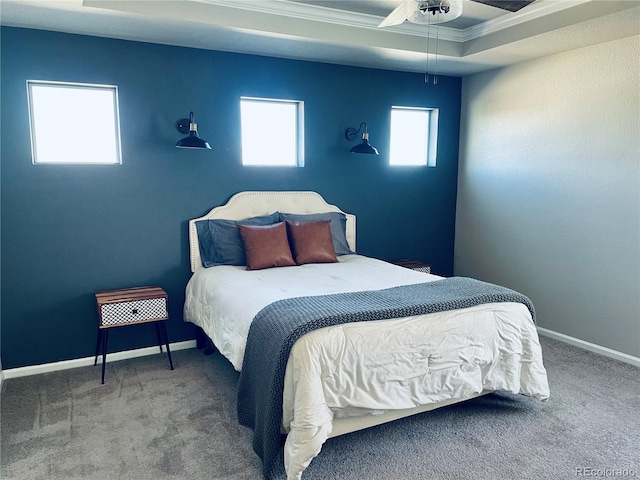 carpeted bedroom with ornamental molding, a raised ceiling, and ceiling fan