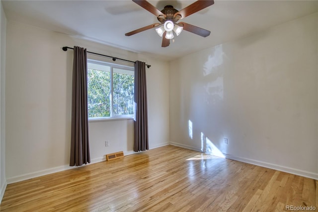 spare room with ceiling fan and light wood-type flooring