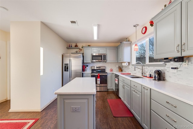 kitchen with gray cabinetry, a sink, visible vents, appliances with stainless steel finishes, and tasteful backsplash