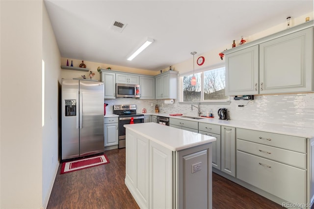 kitchen with stainless steel appliances, gray cabinets, light countertops, visible vents, and backsplash