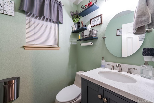 half bathroom featuring toilet and vanity