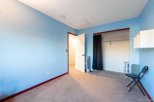 unfurnished bedroom featuring attic access, a closet, baseboards, and carpet flooring