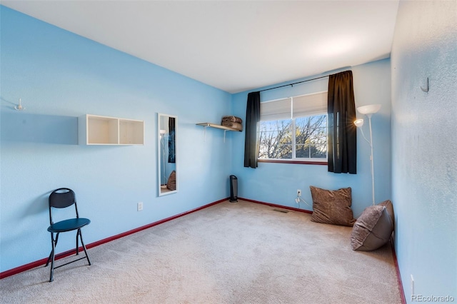 carpeted empty room with visible vents and baseboards