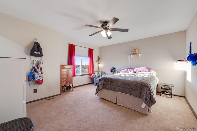 carpeted bedroom featuring a ceiling fan, visible vents, and baseboards