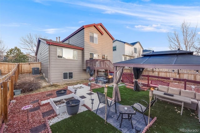 back of house featuring a lawn, a patio area, central AC, a garden, and an outdoor living space