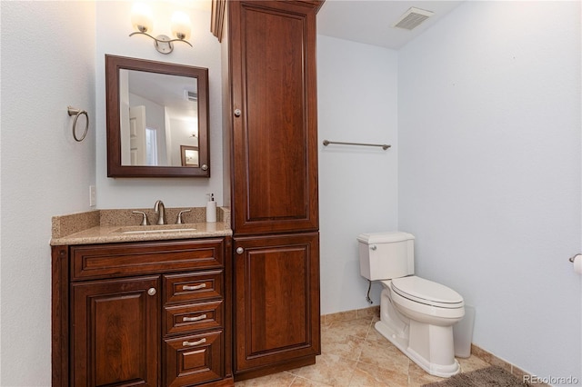 bathroom with tile patterned flooring, vanity, and toilet