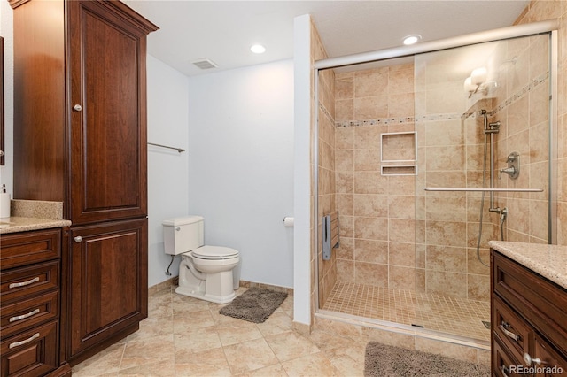 bathroom with vanity, a shower with door, and toilet