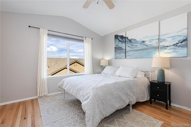 bedroom with hardwood / wood-style floors, vaulted ceiling, and ceiling fan