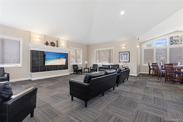 living room with lofted ceiling, dark carpet, and a wealth of natural light