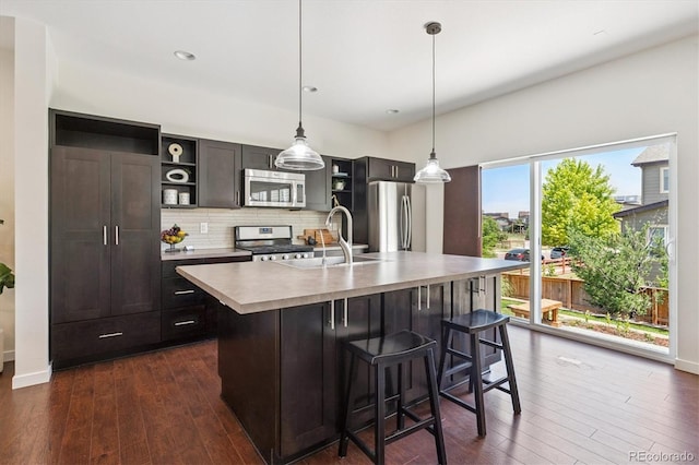10844 Telluride St, Commerce City, CO 80022 - kitchen with appliances with stainless steel finishes, open shelves, dark wood-type flooring, tasteful backsplash, and light countertops