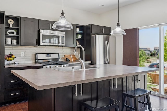10844 Telluride St, Commerce City, CO 80022 - kitchen with stainless steel appliances, open shelves, backsplash, dark wood finished floors, and an island with sink