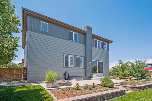 10844 Telluride St, Commerce City, CO 80022 - rear view of house with a patio area, a chimney, and entry steps