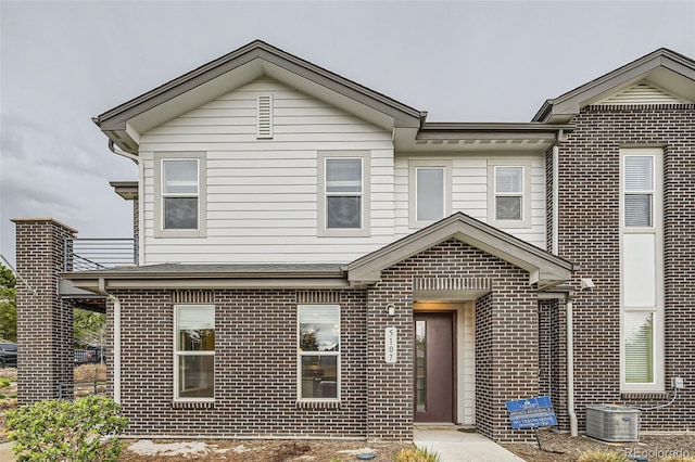 view of front of property with brick siding and cooling unit