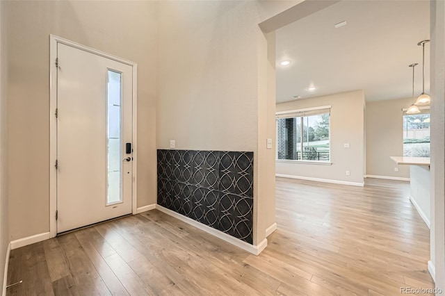 entrance foyer with baseboards and light wood-style flooring