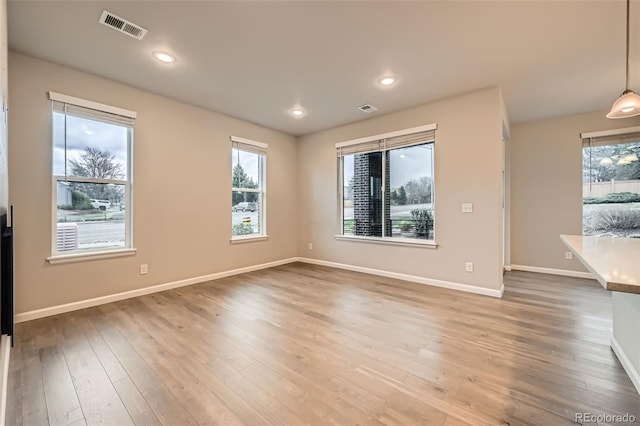 spare room with recessed lighting, baseboards, light wood finished floors, and visible vents