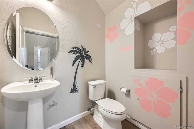 bathroom featuring a sink, baseboards, toilet, and wood finished floors