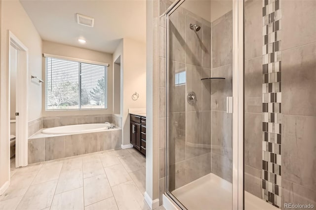 full bathroom with a garden tub, visible vents, vanity, toilet, and a stall shower