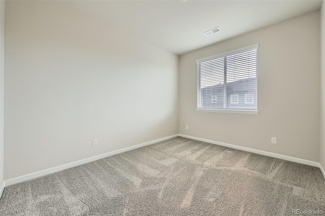 carpeted spare room featuring baseboards and visible vents