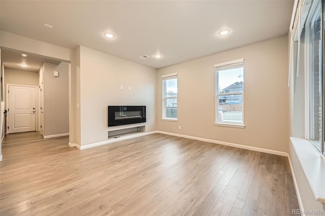 5107 S Fairplay St, Aurora, CO 80015 - unfurnished living room with a glass covered fireplace, baseboards, light wood-style floors, and recessed lighting
