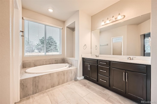 5107 S Fairplay St, Aurora, CO 80015 - bathroom featuring a garden tub, double vanity, and tile patterned flooring