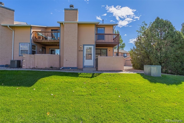 back of house with a yard, a balcony, and central AC