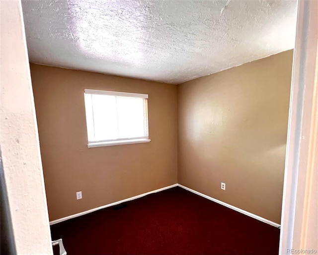 carpeted spare room featuring a textured ceiling