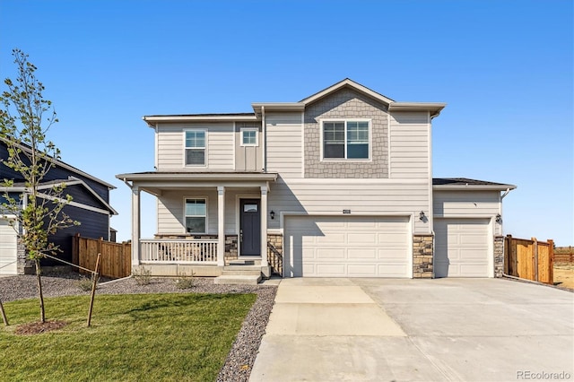 view of front facade with covered porch, concrete driveway, an attached garage, a front yard, and fence