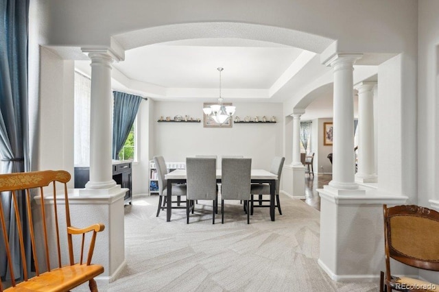 2810 Shadow Dance Dr, Castle Rock, CO 80109 - carpeted dining space with a tray ceiling, arched walkways, ornate columns, a chandelier, and baseboards