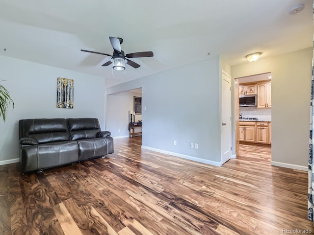 living room featuring hardwood / wood-style floors and ceiling fan