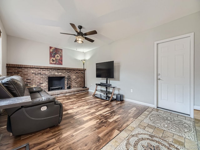 living room with a fireplace, wood-type flooring, and ceiling fan