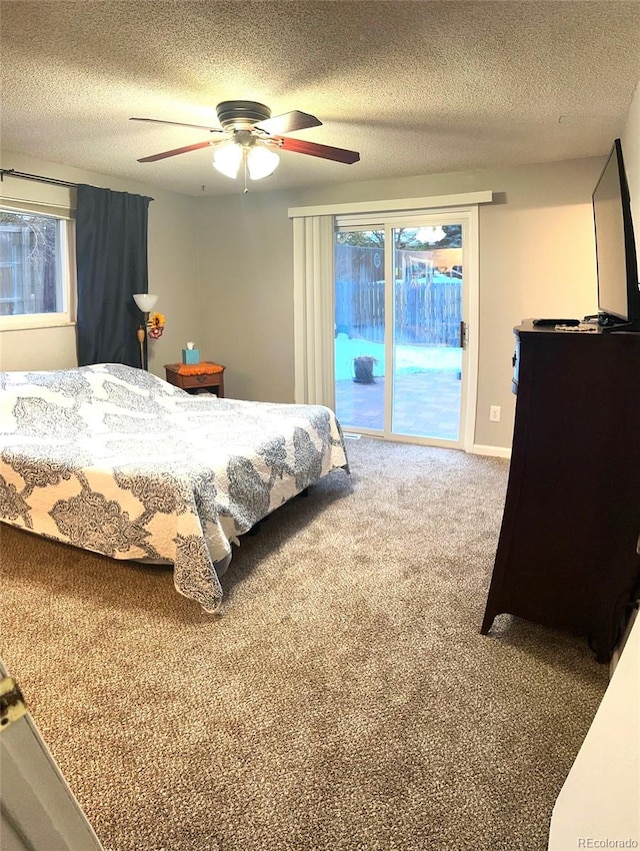 carpeted bedroom with ceiling fan, access to exterior, multiple windows, and a textured ceiling