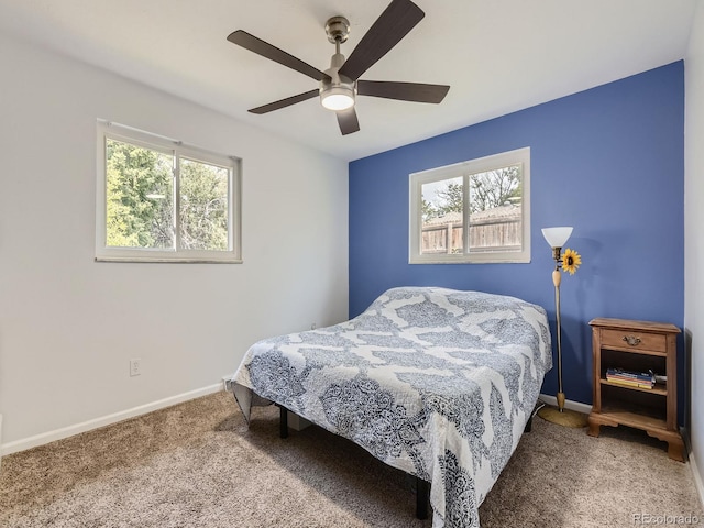 carpeted bedroom featuring ceiling fan and multiple windows