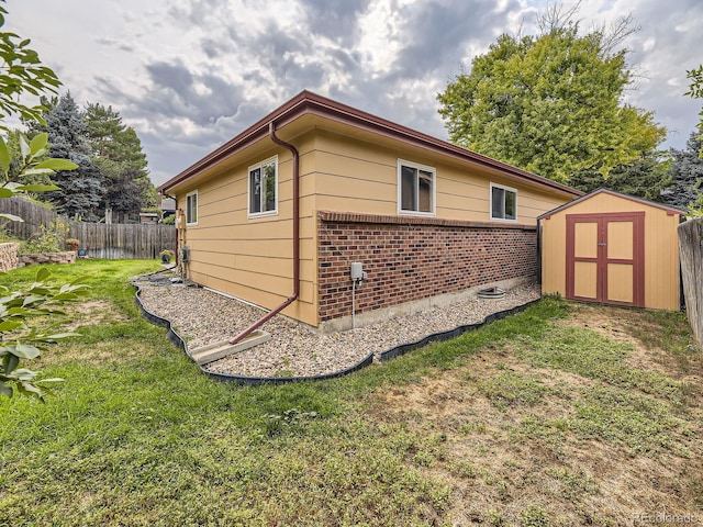 view of side of property featuring a yard and a storage shed