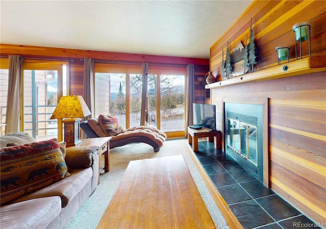 living room with wood walls and a glass covered fireplace