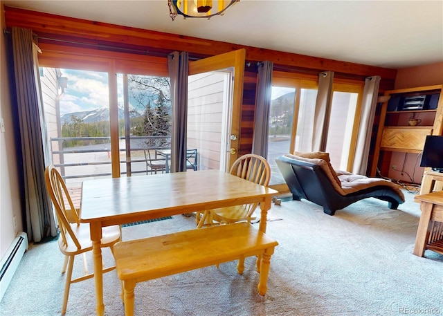 carpeted dining space with a mountain view and a baseboard heating unit