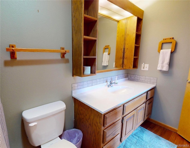 bathroom featuring vanity, toilet, and wood finished floors
