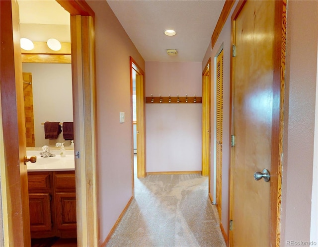 hallway featuring carpet floors, baseboards, and recessed lighting