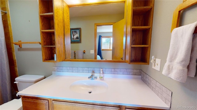 bathroom with toilet, curtained shower, and vanity