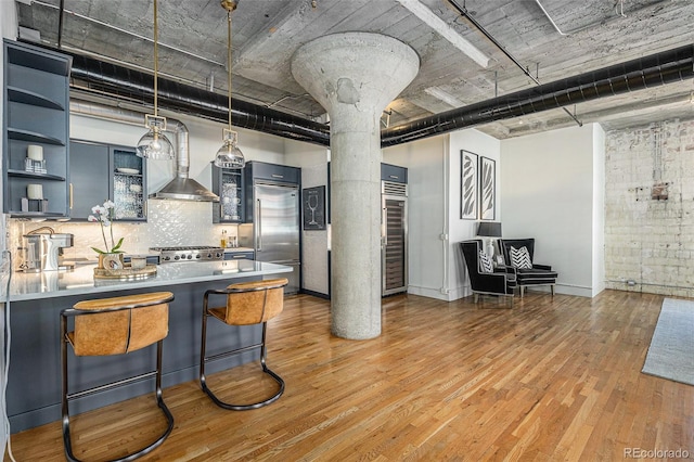 1863 Wazee St Unit 4E, Denver, CO 80202 - kitchen featuring built in refrigerator, open shelves, decorative columns, light wood-style floors, and glass insert cabinets