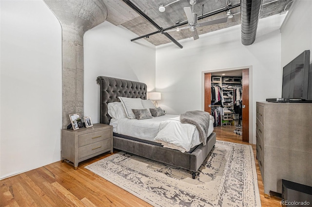 1863 Wazee St Unit 4E, Denver, CO 80202 - bedroom featuring wood finished floors, a spacious closet, a towering ceiling, and a closet