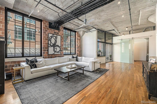 1863 Wazee St Unit 4E, Denver, CO 80202 - living area with track lighting, wood finished floors, a ceiling fan, healthy amount of natural light, and brick wall