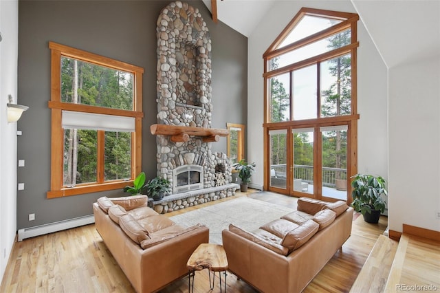 30 Carroll Ct, Black Hawk, CO 80422 - living area featuring baseboard heating, high vaulted ceiling, wood finished floors, a stone fireplace, and baseboards