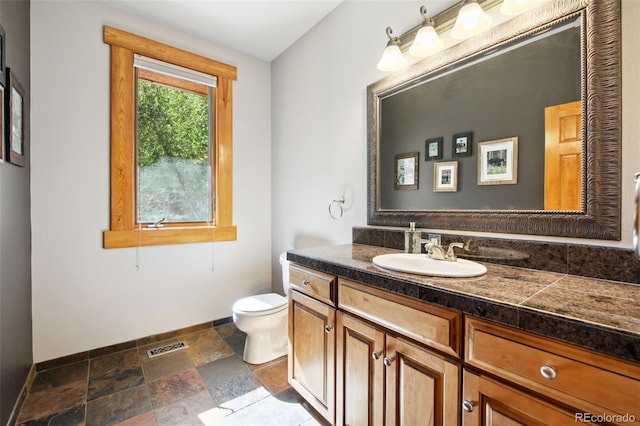 30 Carroll Ct, Black Hawk, CO 80422 - bathroom with baseboards, stone tile floors, vanity, and toilet