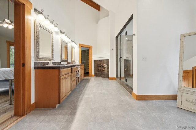 30 Carroll Ct, Black Hawk, CO 80422 - ensuite bathroom with a towering ceiling, vanity, a shower stall, ceiling fan, and a fireplace