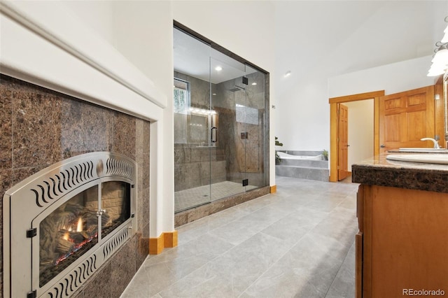 30 Carroll Ct, Black Hawk, CO 80422 - bathroom featuring a warm lit fireplace, a stall shower, double vanity, a bathtub, and tile patterned floors