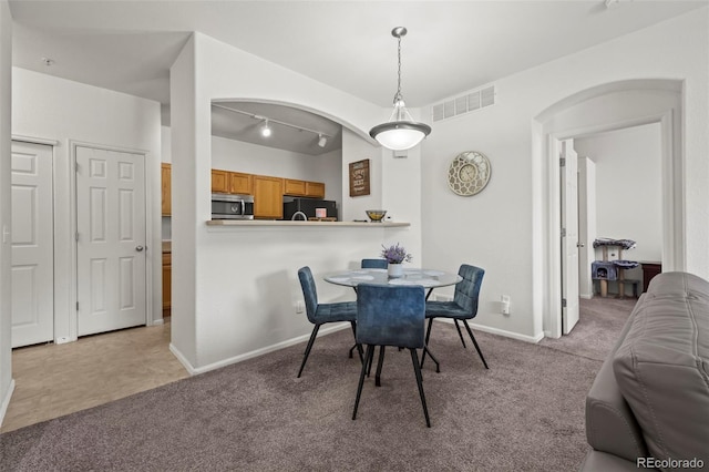 5255 Memphis St Unit 811, Denver, CO 80239 - dining room with light carpet, arched walkways, and rail lighting