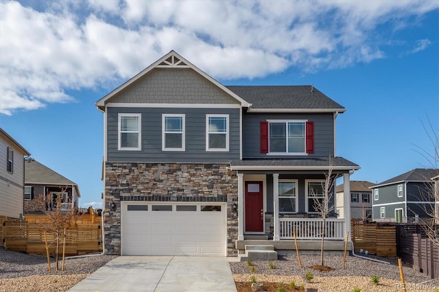 27664 E Byers Ave, Aurora, CO 80018 - craftsman house featuring covered porch, fence, stone siding, and an attached garage