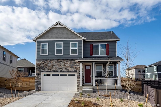 27664 E Byers Ave, Aurora, CO 80018 - craftsman house featuring covered porch, fence, a garage, driveway, and stone siding