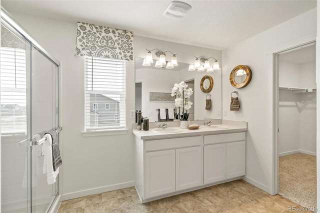 27664 E Byers Ave, Aurora, CO 80018 - bathroom with plenty of natural light, a shower stall, baseboards, and double vanity